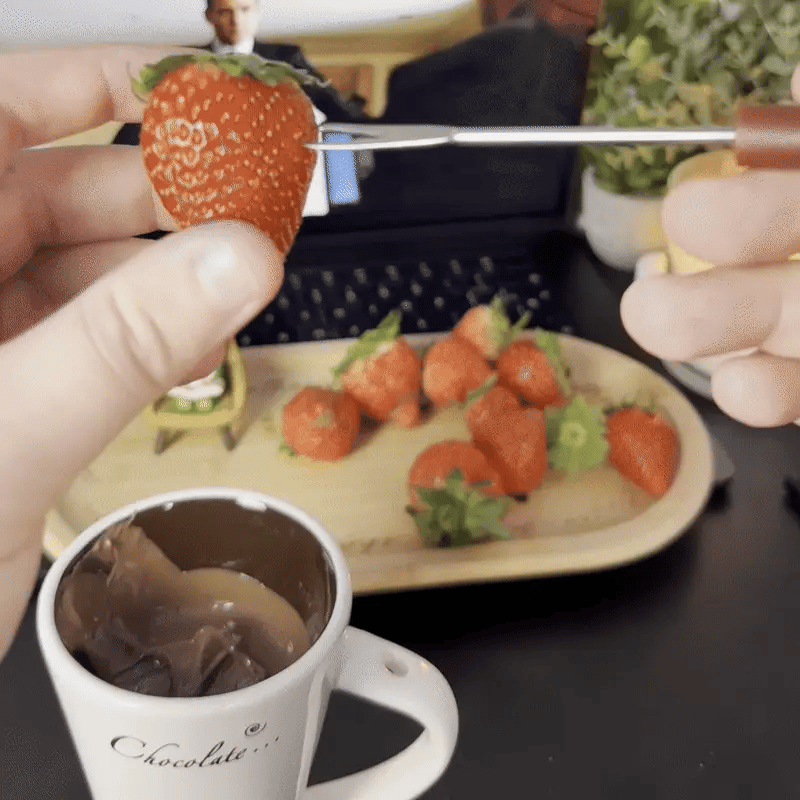 Detailaufnahme, wie Kekse in die geschmolzene Schokolade getaucht werden